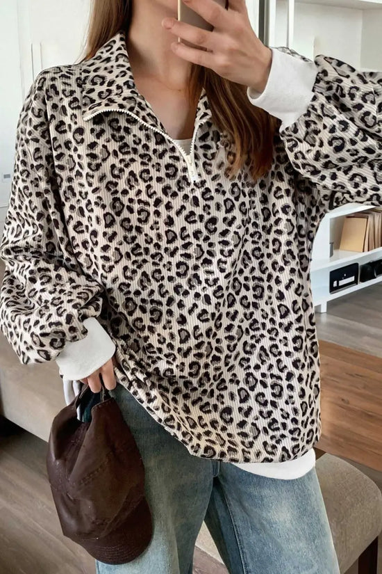 Model wearing a white variation of the Women's Leopard Print Corduroy Half-Zip Jumper styled with jeans for a casual look.