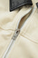 Close-up of a beige jacket with a silver zipper