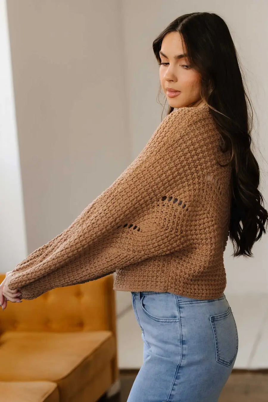 Side angle of brown wide sleeve hollow knit jumper paired with jeans, showing loose fit and breathable knit for daily wear.