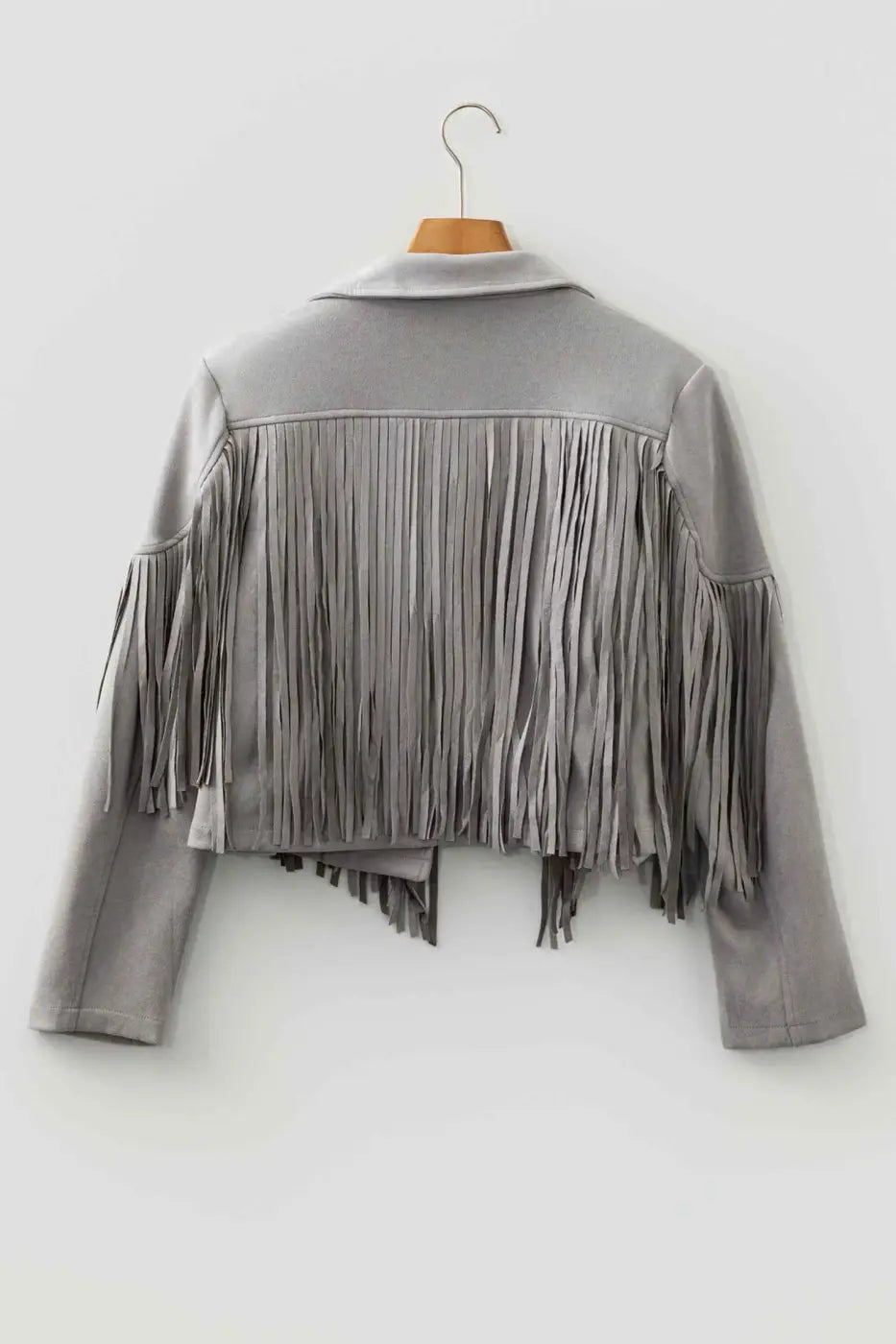 Back view of gray cropped fringe faux suede jacket on hanger, showcasing full-length fringe and structured shoulder design.