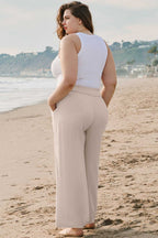 Rear view of model in Wide Leg Plus Linen Pants, highlighting elastic waist and soft drape. Fashionfitz plus size summer trousers in solid beige.