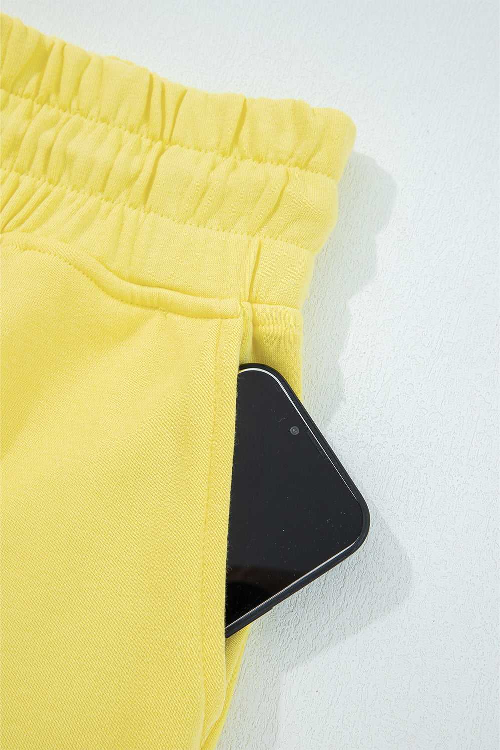 Pocket detail of yellow Drop Crop Wide-Leg Pants Set with phone, showcasing practicality in casual loungewear design.