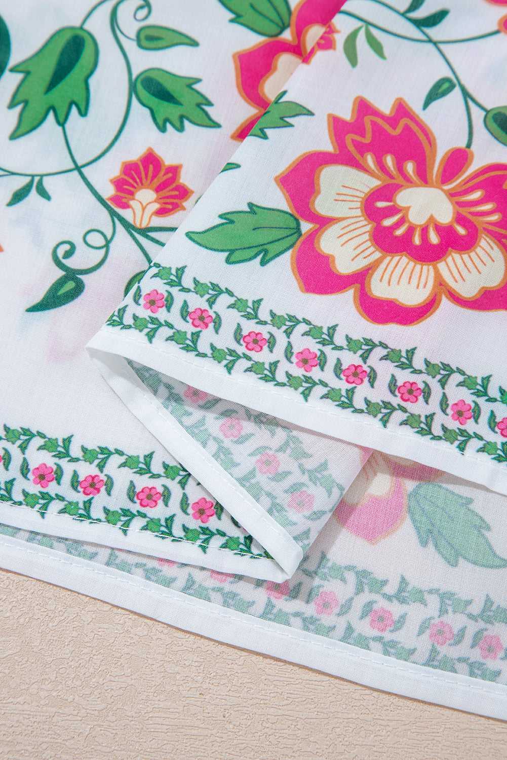 Hemline close-up of White Floral Mandarin Maxi Dress featuring floral border and lightweight fabric for breezy spring style.