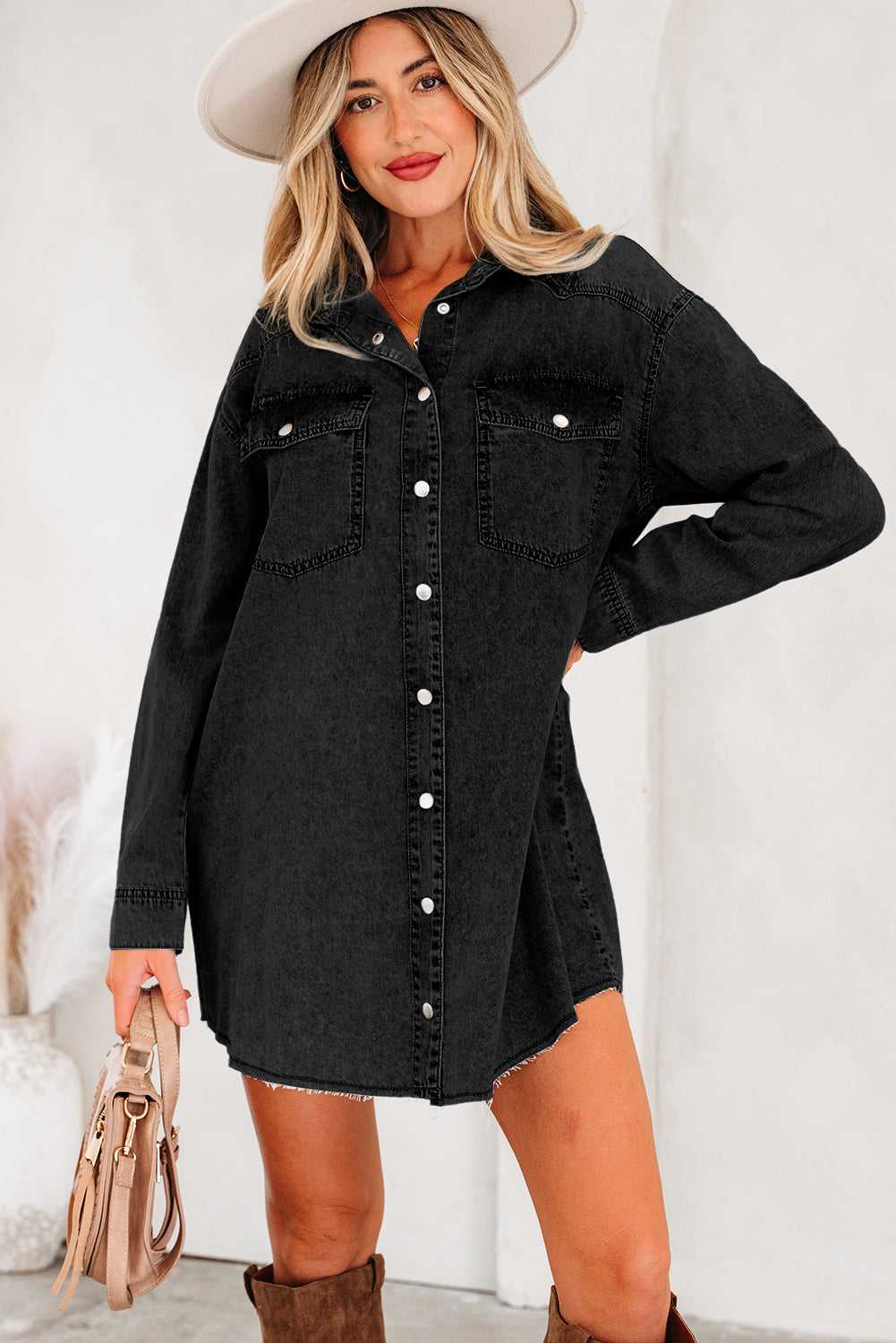 Casual black oversized denim dress for women with raw hem, button front, and long sleeves, styled with boots for a chic autumn outfit.
