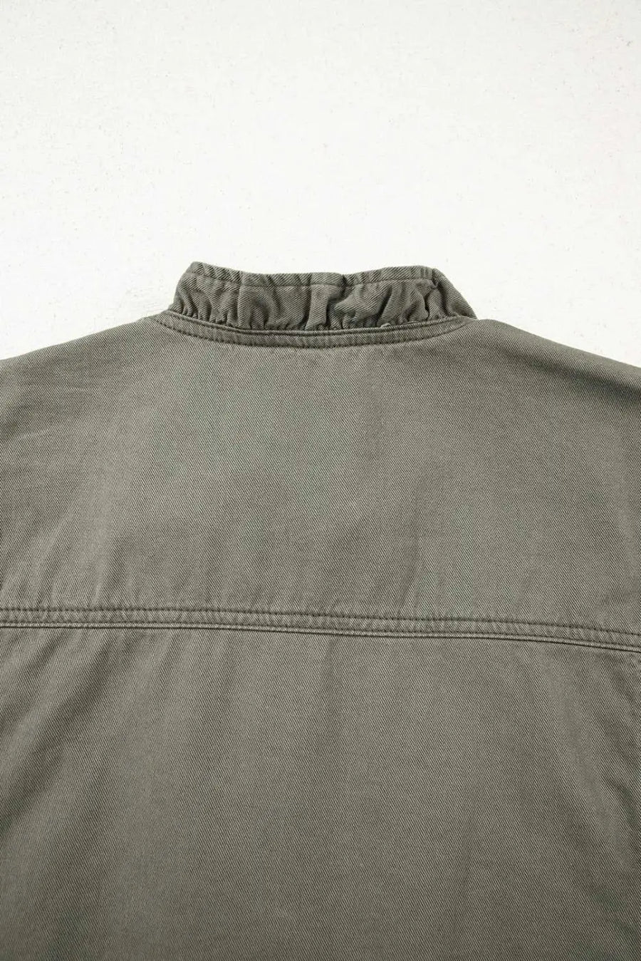 Back neckline detail of Green Bay Ruffled Denim Vest - Women's Fashion Trends with subtle ruffle trim and structured stitching.