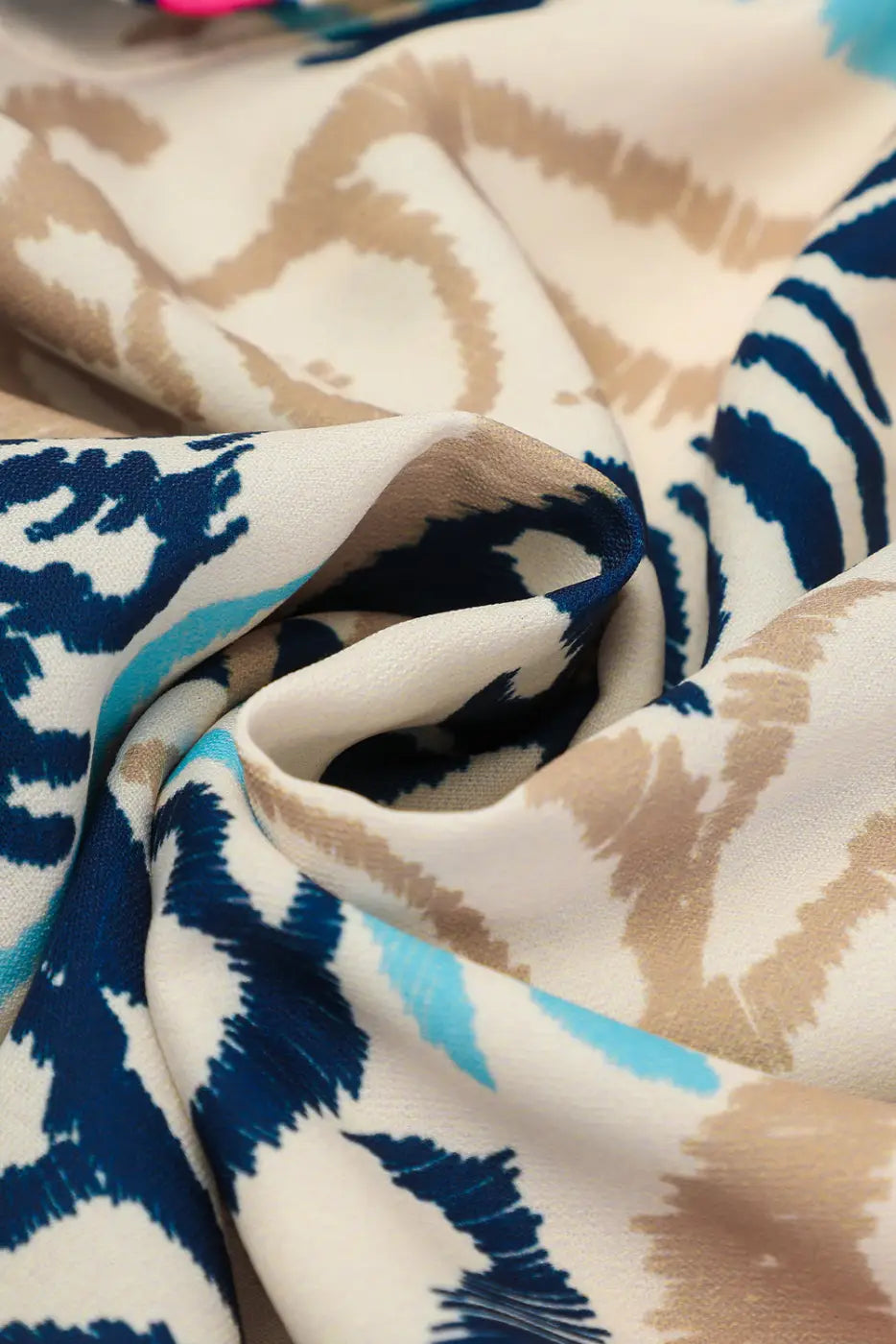 Fabric close-up of the Tribal Mini Dress, showing soft texture and vibrant bohemian print in blue, beige, and pink tones.