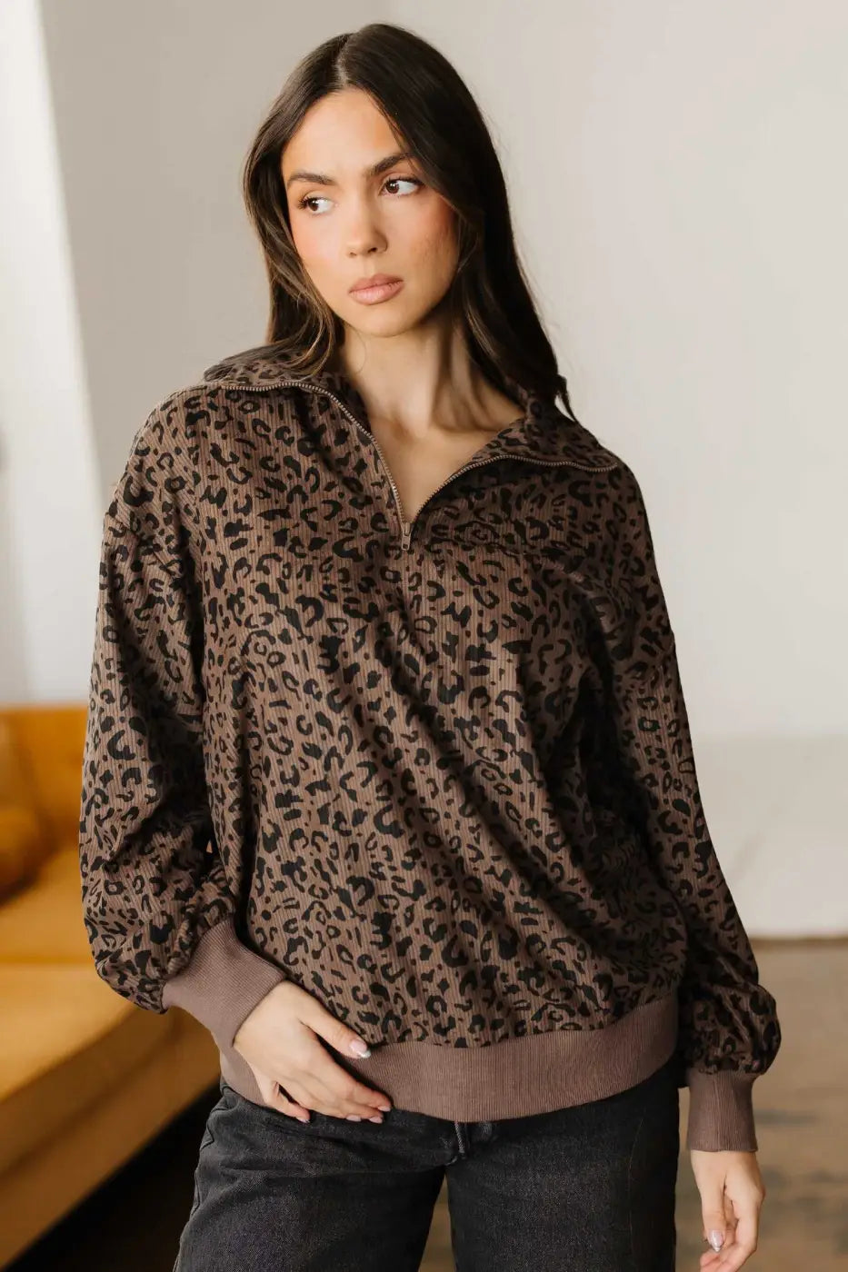 Model showcasing the Women's Brown Leopard Print Corduroy Half-Zip Jumper styled with dark jeans, perfect for autumn wear.