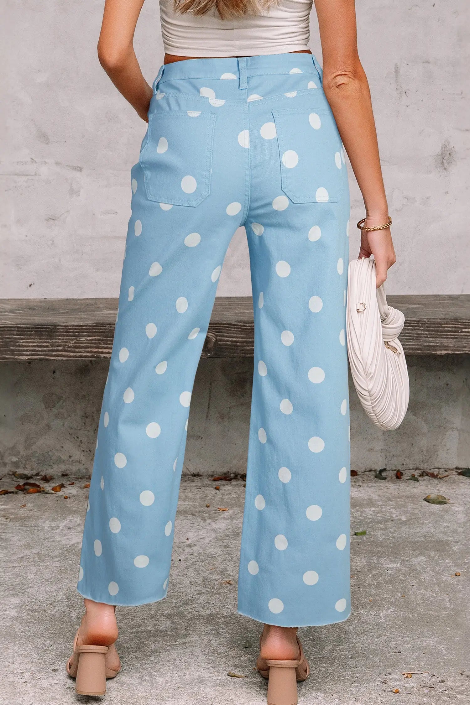 Close-up of sky blue polka dot print denim fabric and raw hem finish on straight leg jeans Fashionfitz UK
