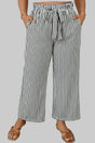 Person wearing black and white striped wide-leg pants in a bathroom setting.