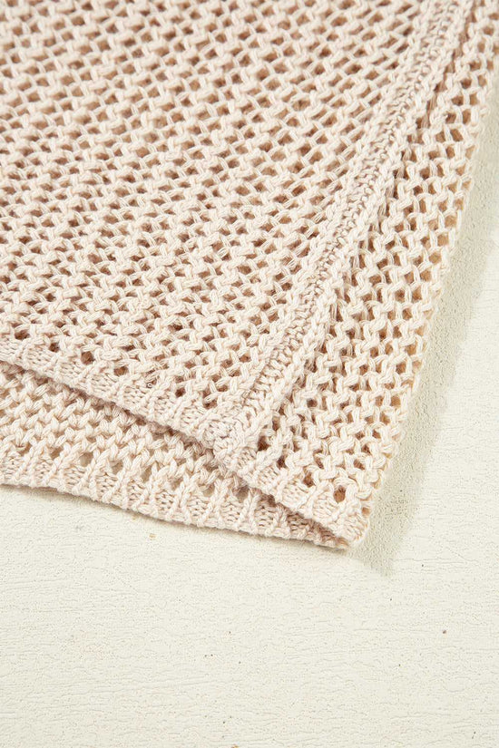 Close-up of a folded beige crochet blanket on a light background