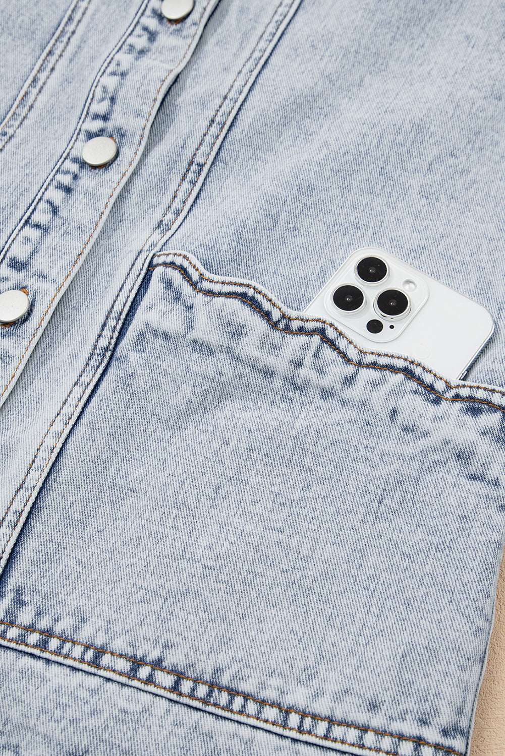 Front pocket of Beau Blue Scallop‑Trim Denim Waistcoat holding a smartphone, demonstrating practical storage in stylish outerwear.