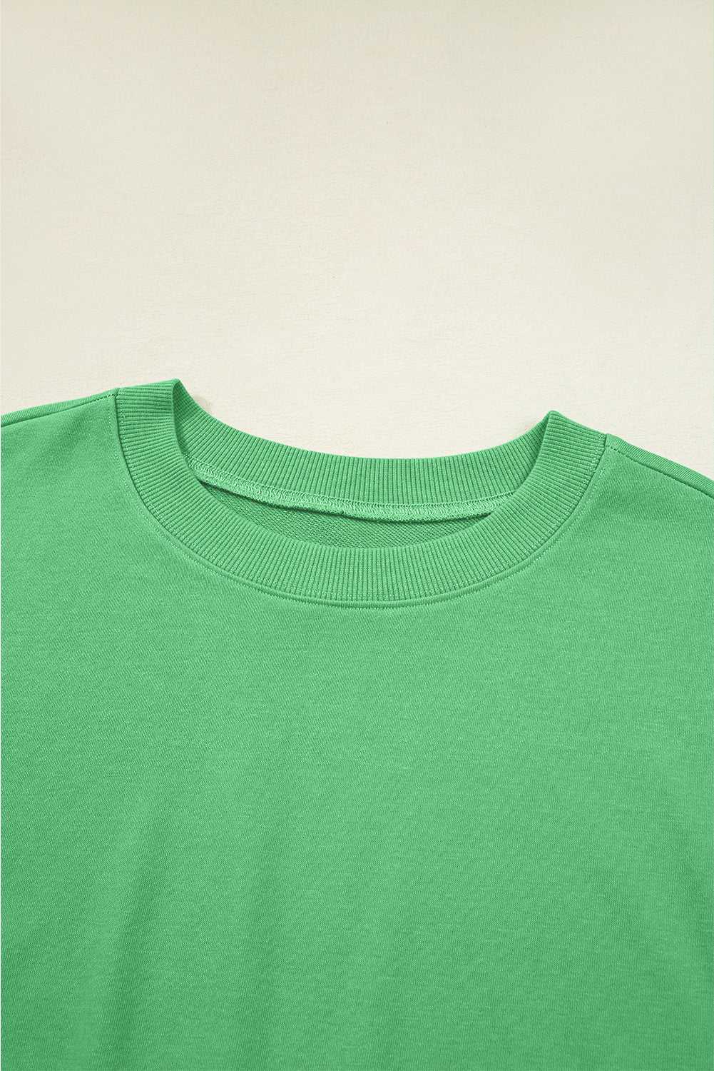 Close-up of green Drop Crop Set neckline with ribbed trim, offering a detailed look at the top's casual design.
