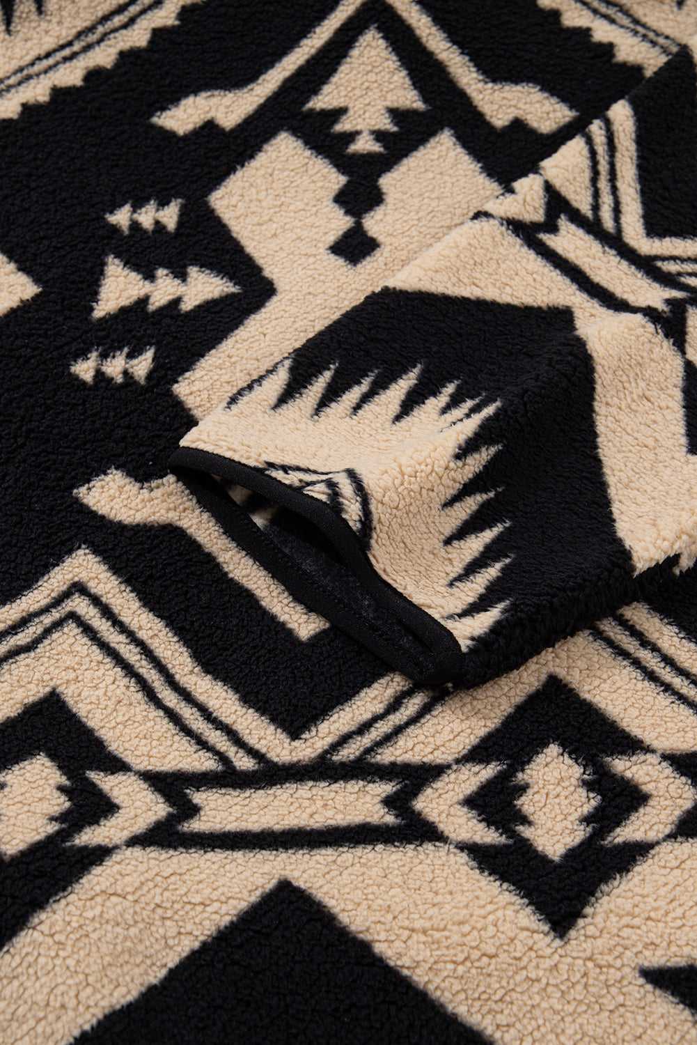 Sleeve detail of Women's Black Plus Size Aztec Print Plush Sweatshirt with Western-style pattern and plush fleece finish for added warmth.