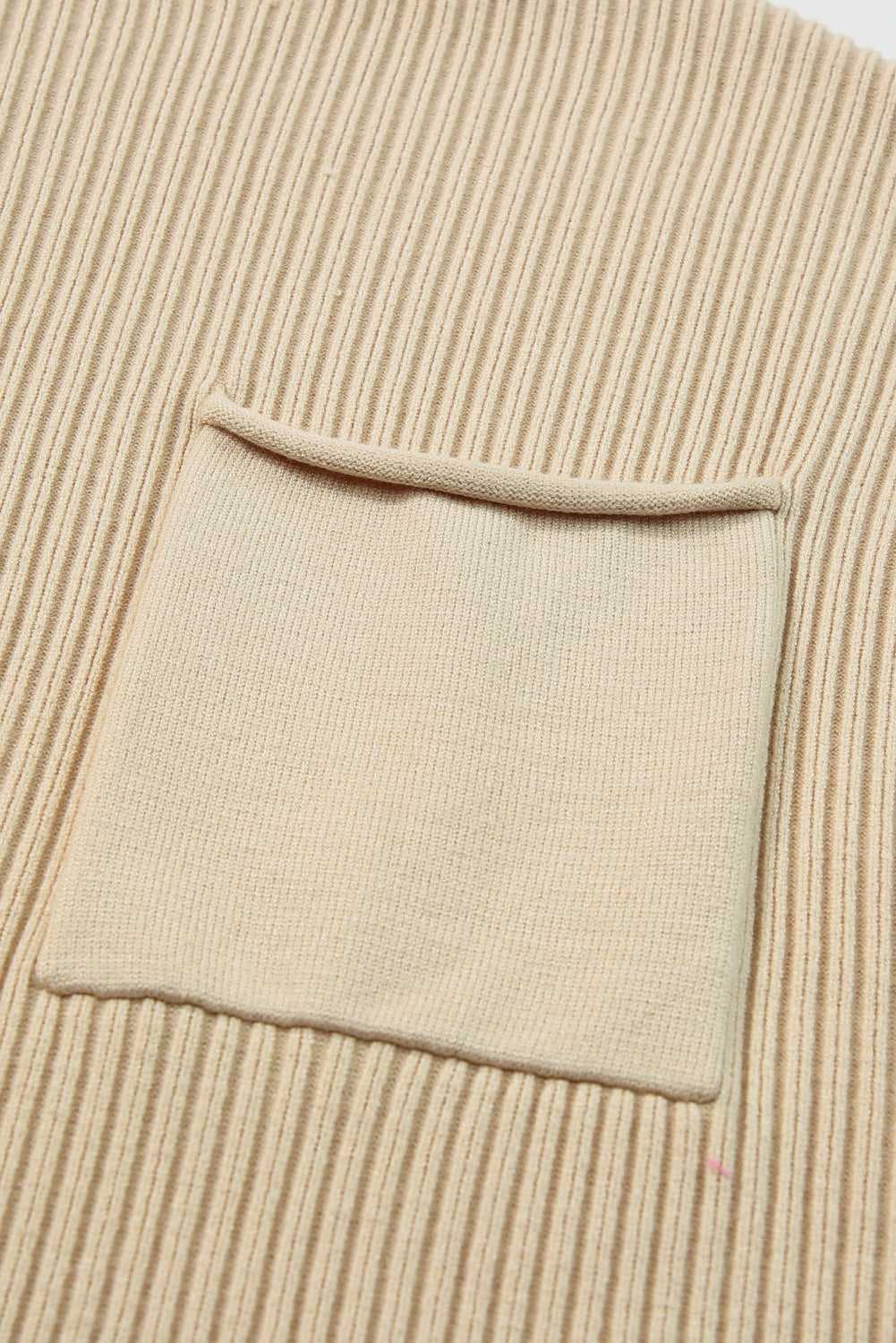 Detailed view of the chest pocket on the oatmeal ribbed knit sweater dress, showcasing its practical and stylish design.