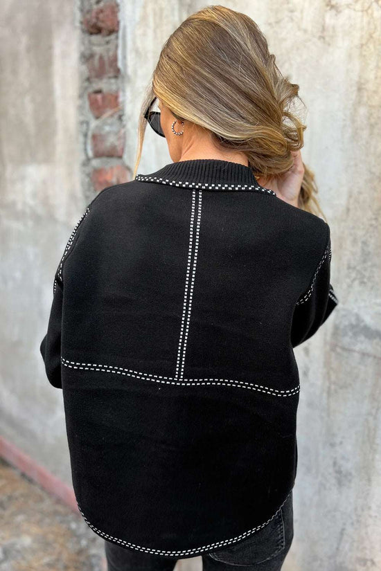 Back view of Women's Black Contrast Trim Knitted Cardigan with vertical and horizontal white stitched accents for a modern look.