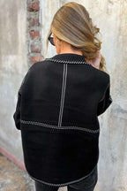 Back view of Women's Black Contrast Trim Knitted Cardigan with vertical and horizontal white stitched accents for a modern look.