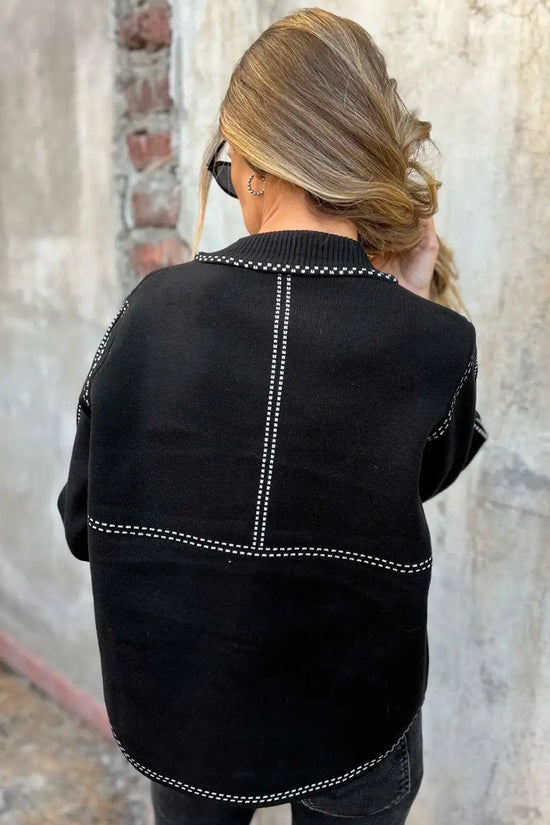 Back view of Women's Black Contrast Trim Knitted Cardigan with vertical and horizontal white stitched accents for a modern look.