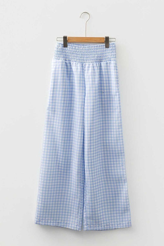 Waistband and pleat detail of plaid culotte-style trousers