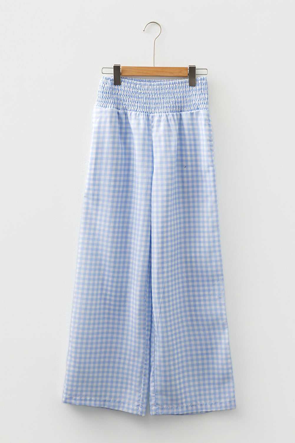 Waistband and pleat detail of plaid culotte-style trousers