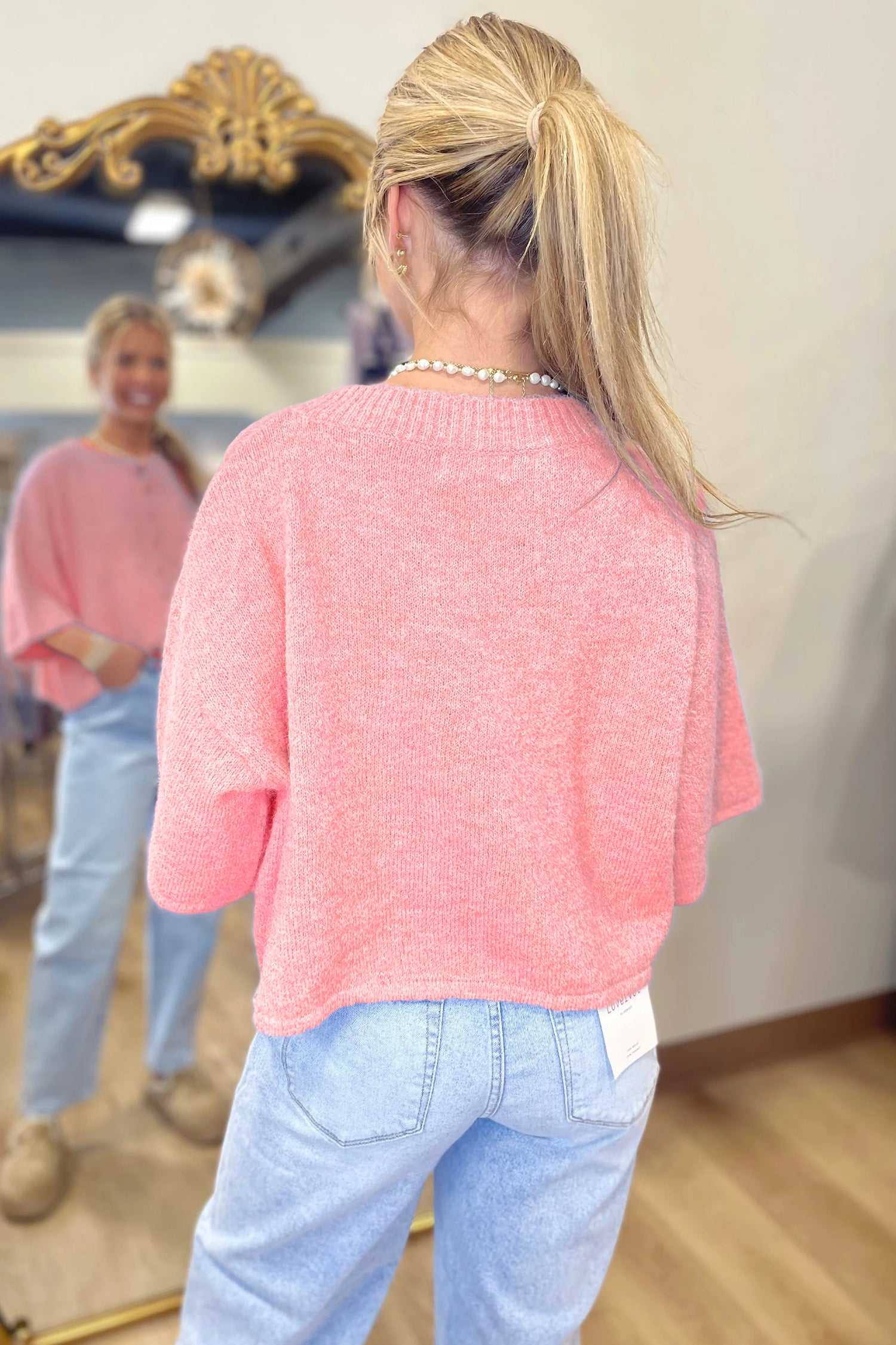 Back view of pastel peach fuzzy knit cardigan with relaxed boxy silhouette and short sleeves, ideal for layering.