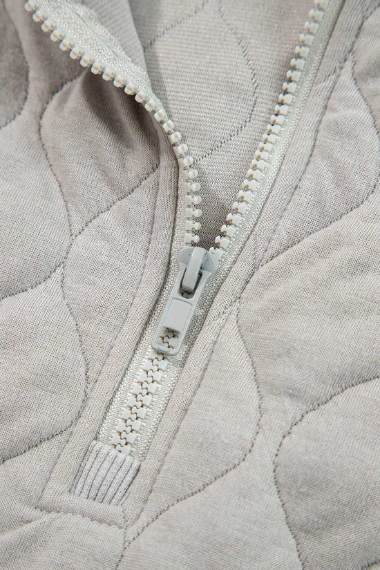 Close-up of zipper on curve grey quilted quarter-zip hoodie, highlighting quality stitching and durable hardware for everyday wear.