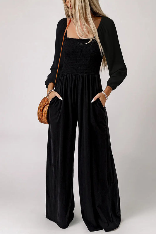 Woman wearing black smocked square neck wide leg jumpsuit with long sleeves front view Fashionfitz UK