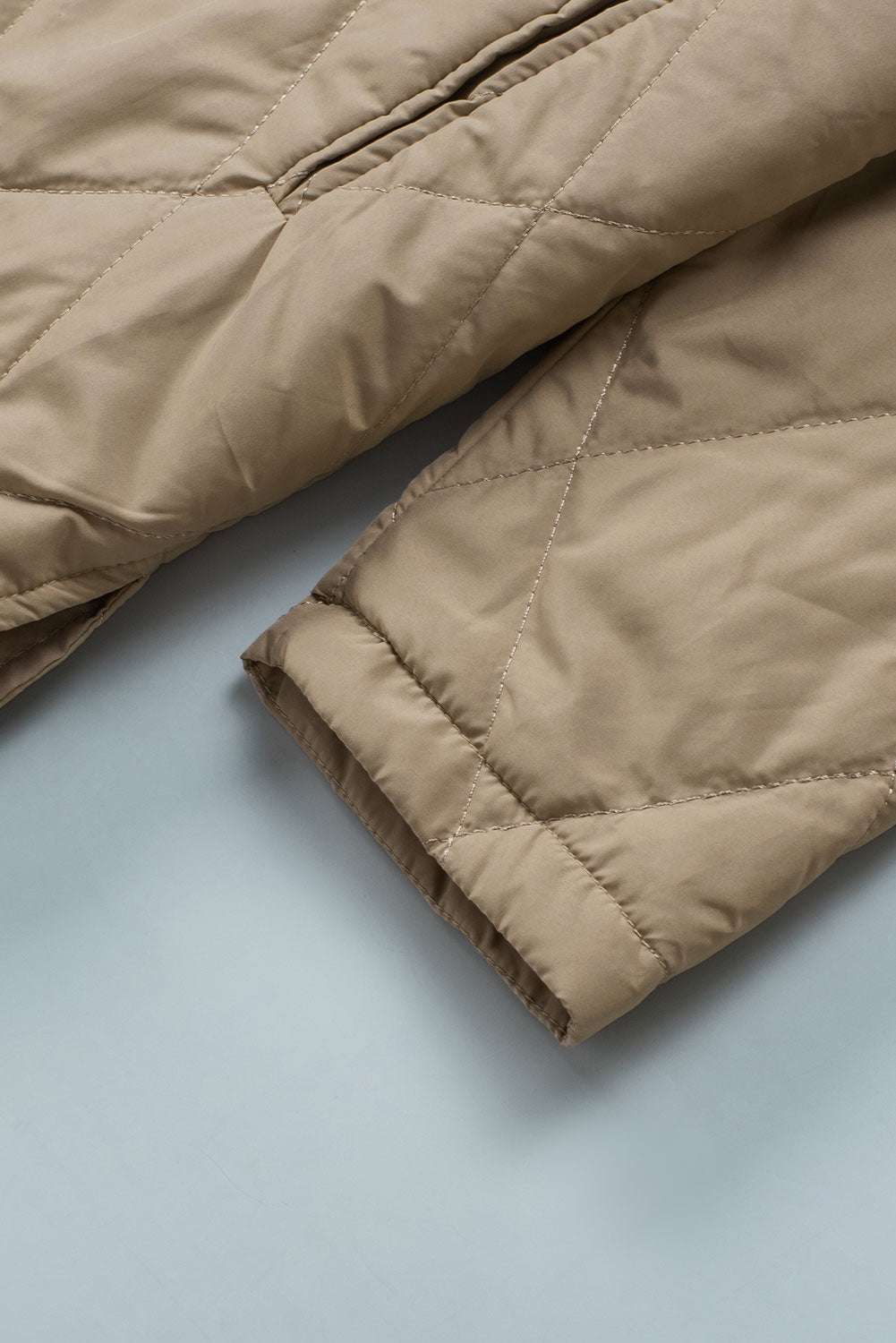 Detailed sleeve view of Khaki Quilted Puffer Jacket – Hooded Snap Button Coat with visible stitching and soft fabric texture for cold weather wear.