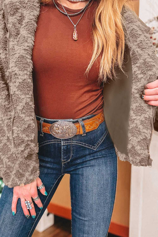Open view of Camel Sherpa Fleece Jacket revealing smooth inner lining, paired with a brown top and western belt for a stylish winter outfit.