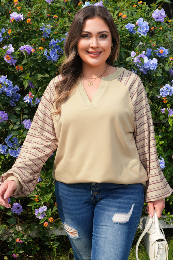 Woman wearing striped raglan sleeve notched neck plus size jumper