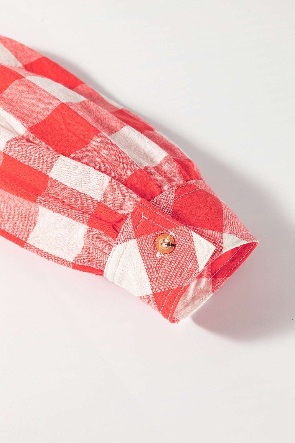 Red plaid shirt sleeve with button detail