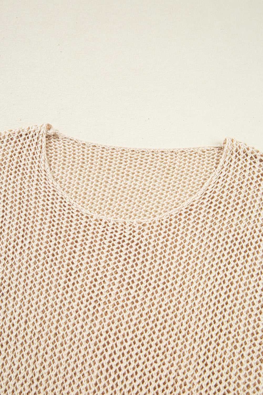 Close-up of a beige knitted sweater on a light beige background