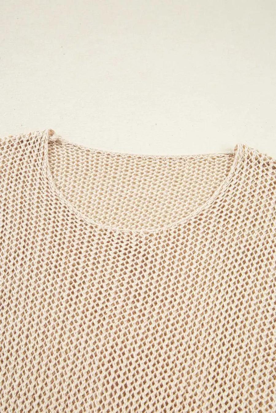 Close-up of a beige knitted sweater on a light beige background