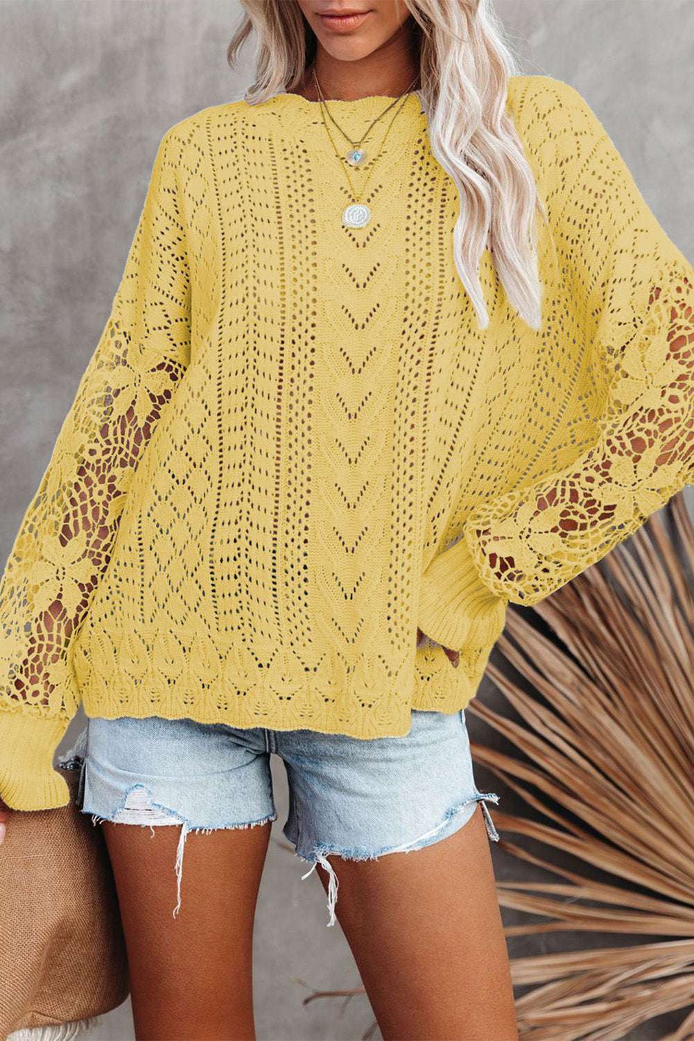 Yellow Crochet Lace Pointelle Knit Sweater styled with denim shorts, featuring intricate lace sleeves and a relaxed fit for spring fashion.