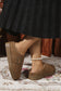 Brown vegan suede clog slippers worn with a black skirt on a patterned rug.