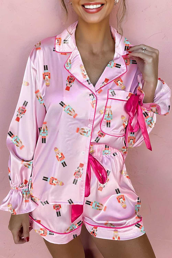 Model wearing pink satin Nutcracker pyjama set with bow detail and contrast trim