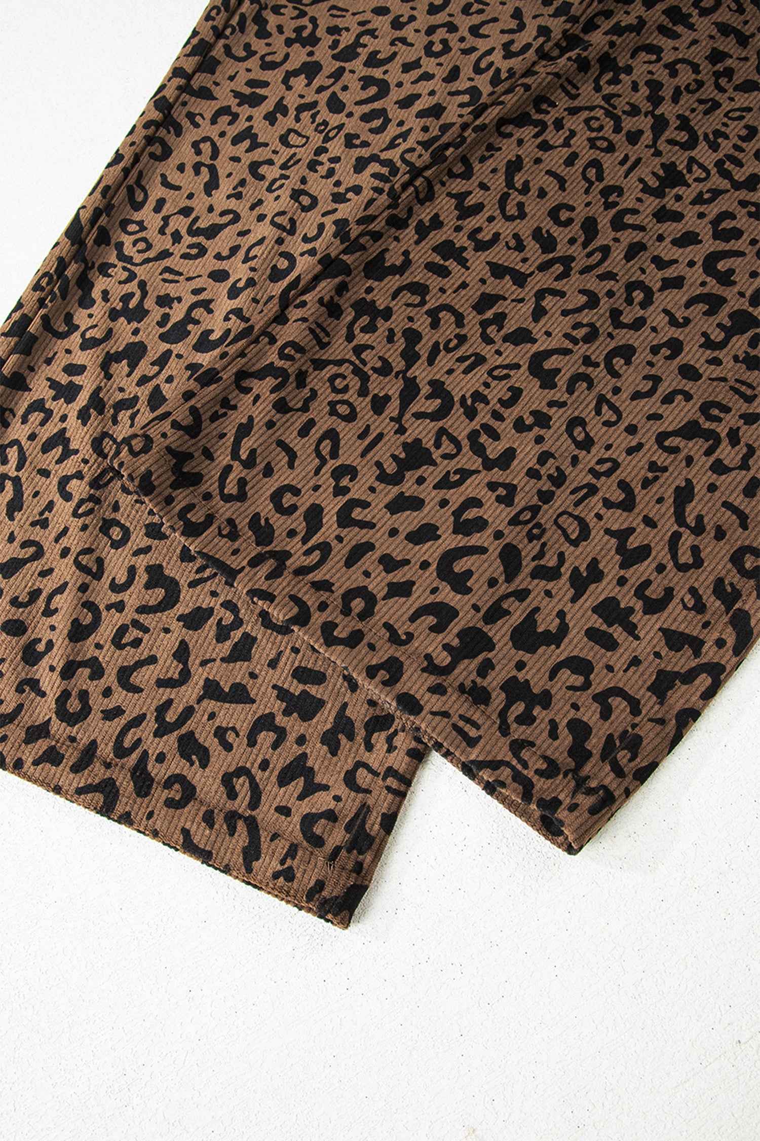 Flat lay of leopard corduroy trousers women in brown, showing detailed hem and all-over animal print for stylish fall outfits.
