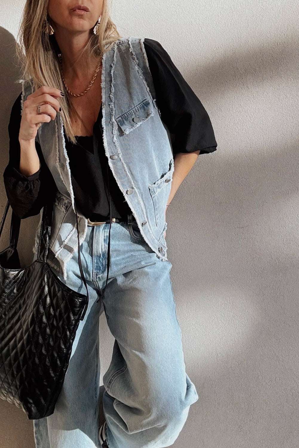 Relaxed fit Beau Blue Denim Waistcoat with Frayed Edges worn over a black blouse and light denim jeans, styled for a casual streetwear outfit.