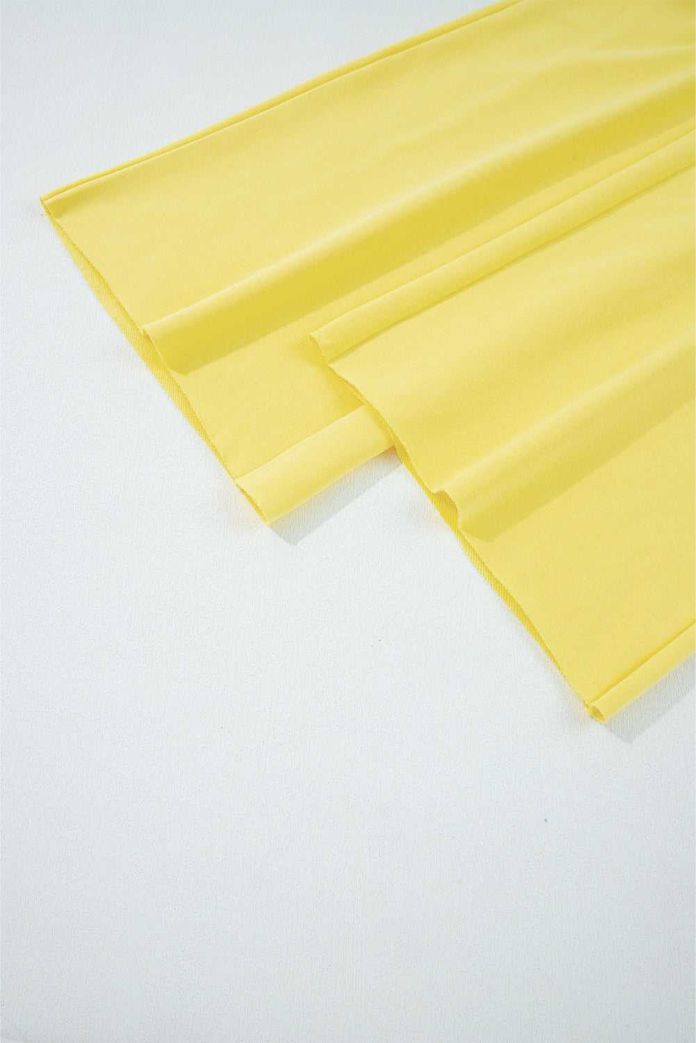 Wide-leg hem detail of yellow Drop Crop Pants, emphasizing flowy silhouette and relaxed fit for fall fashion.