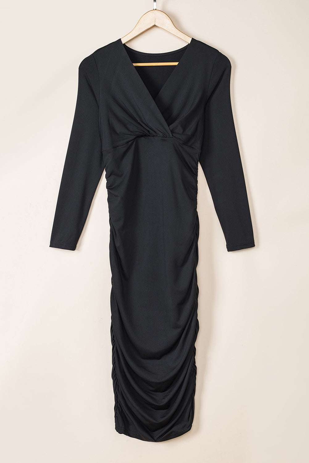 Ladies Black Wrap Drape Midi Dress on hanger displaying full-length design with V-neck and ruched sides, ideal for fall fashion.