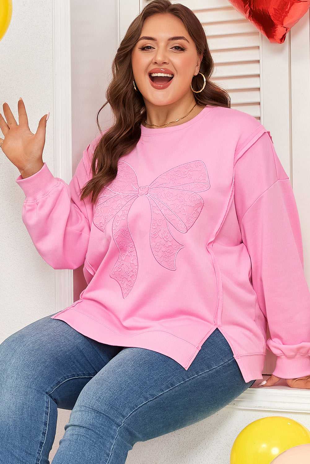 Stylish Plus Size Pink Bow Sweatshirt with lace bow print, worn with jeans. Perfect for autumn comfort with a Southern Belle vibe.