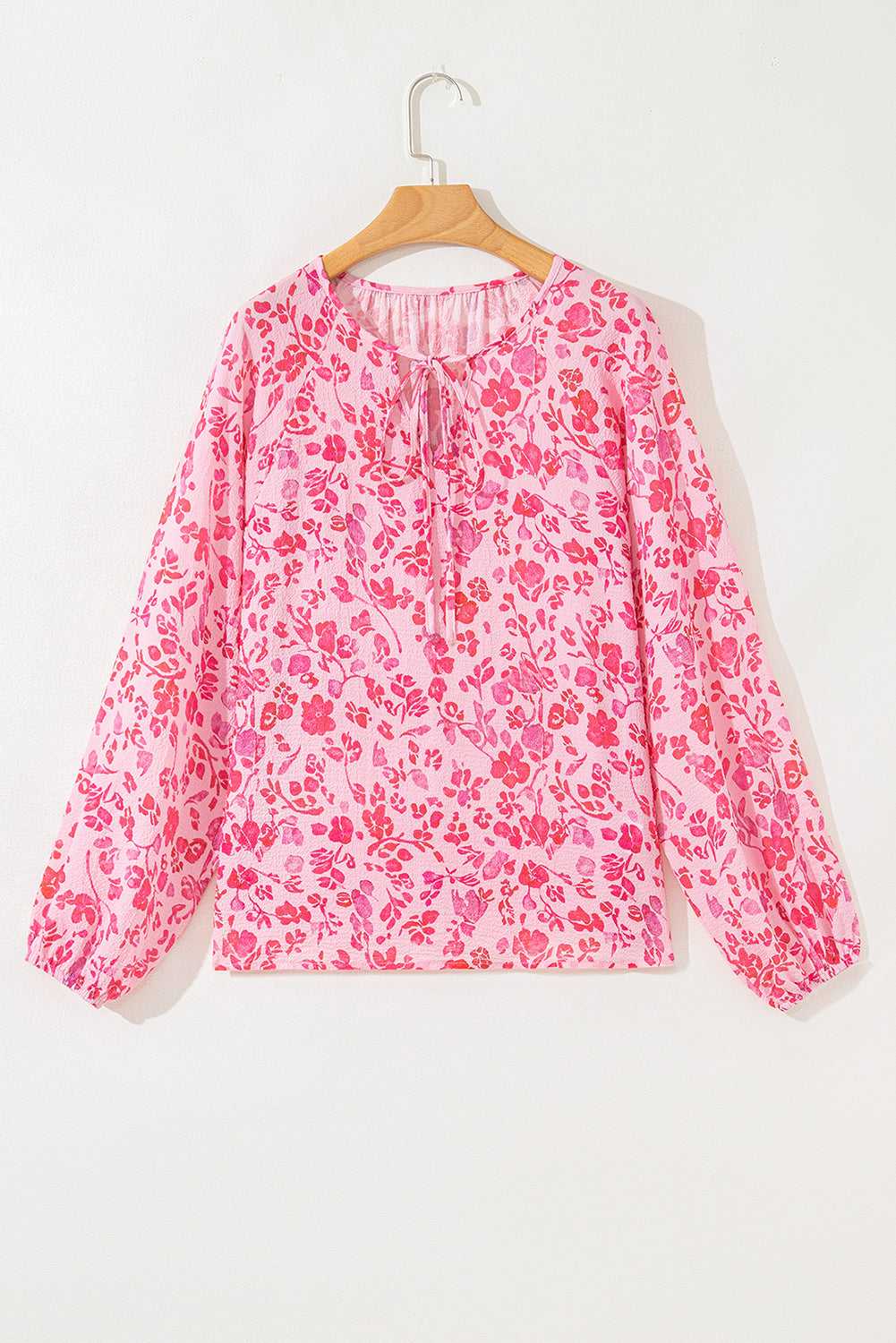Flat lay of Pink Floral Lightweight Blouse on hanger, highlighting its long sleeves and pink floral print.