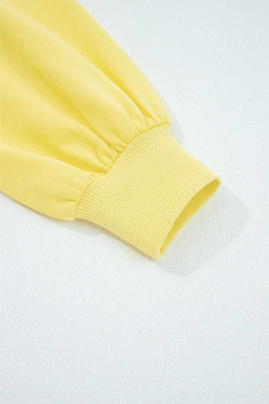 Close-up of yellow Drop Crop Set sleeve cuff with ribbed finish, emphasizing casual style and snug fit.