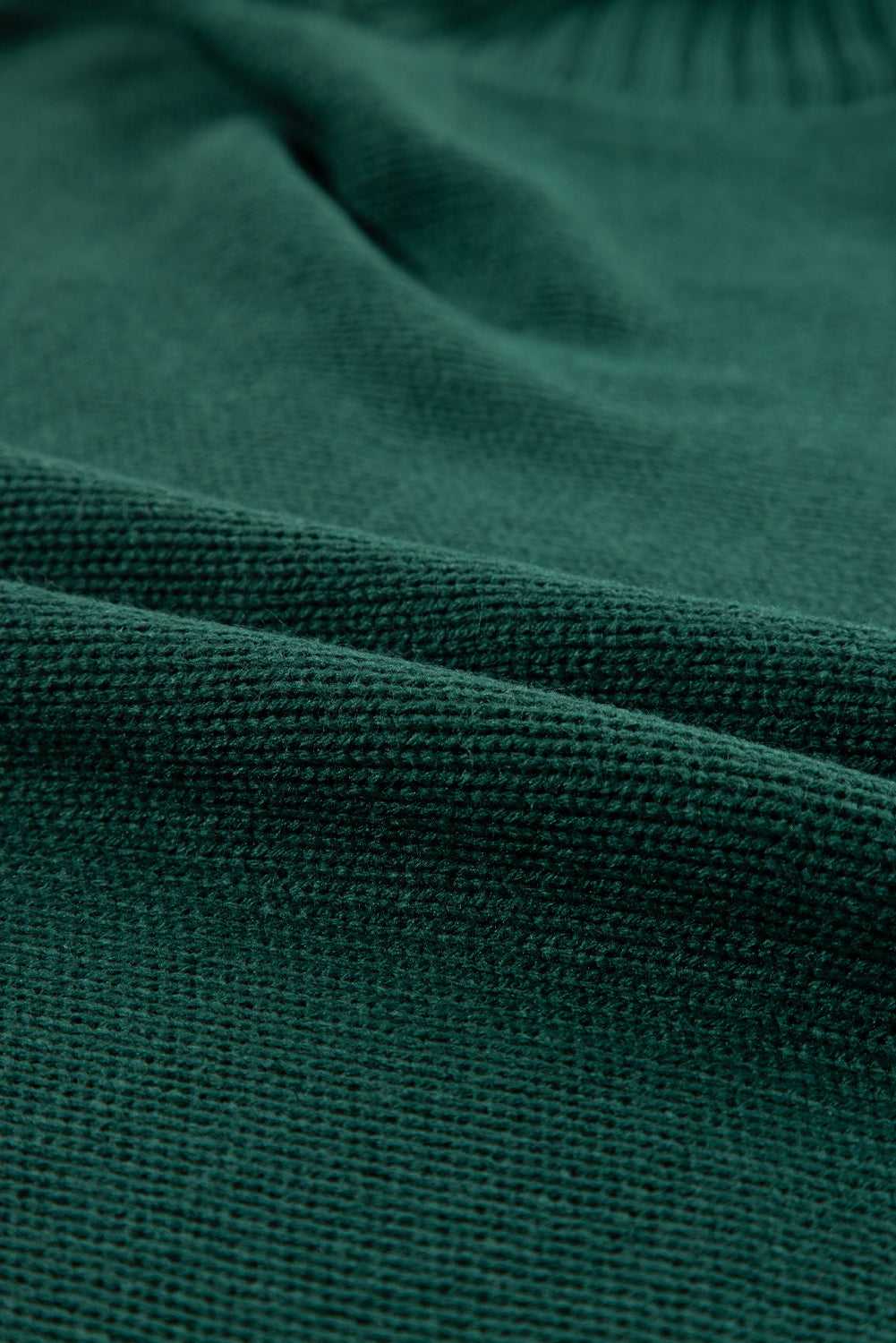 Macro shot of green acrylic knit fabric from the Stylish High Neck Red Sweater - Christmas, showing soft texture and tight weave.