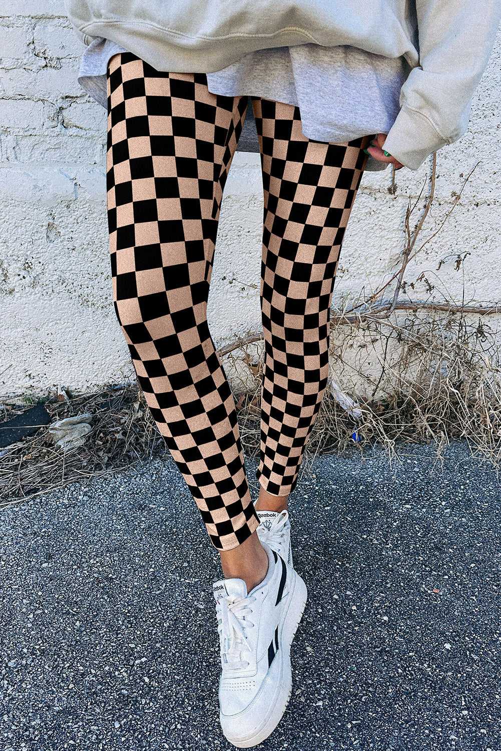 Checkered Skinny Leggings in black and beige with a snug fit, styled casually with sneakers for a trendy streetwear look.