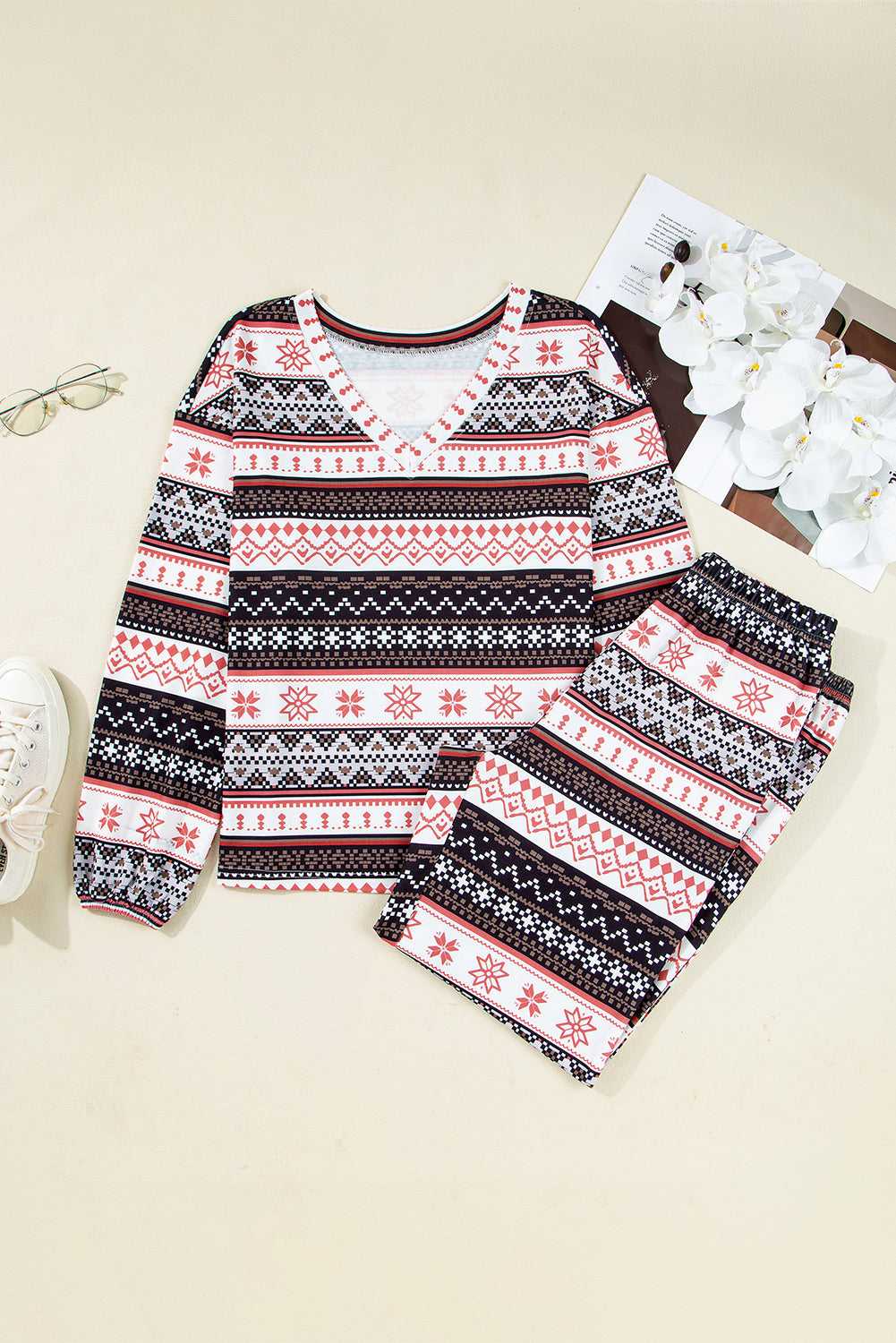 Flat lay of Women's Christmas Comfort Lounge Set in Black by FashionFitz, showing long-sleeve top and pants with red and black holiday print.