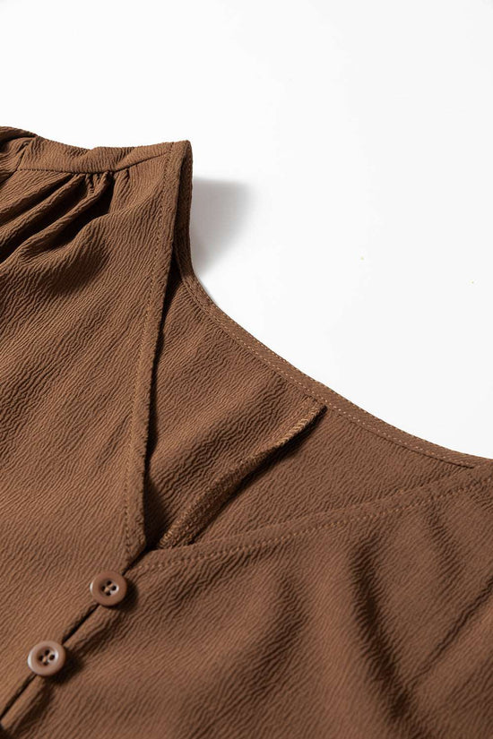 Close-up of neckline and shoulder detail on Brown Long Sleeve Tiered Maxi Dress, showing textured fabric and V-neck cut.