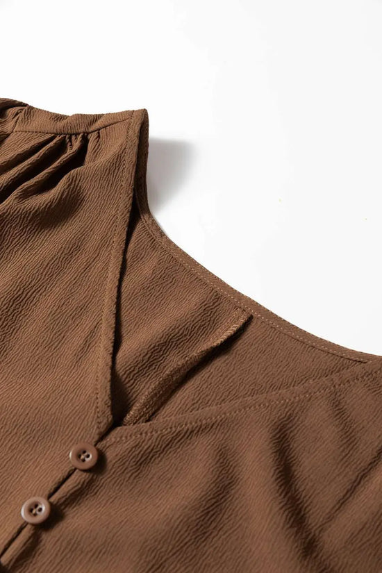 Close-up of neckline and shoulder detail on Brown Long Sleeve Tiered Maxi Dress, showing textured fabric and V-neck cut.