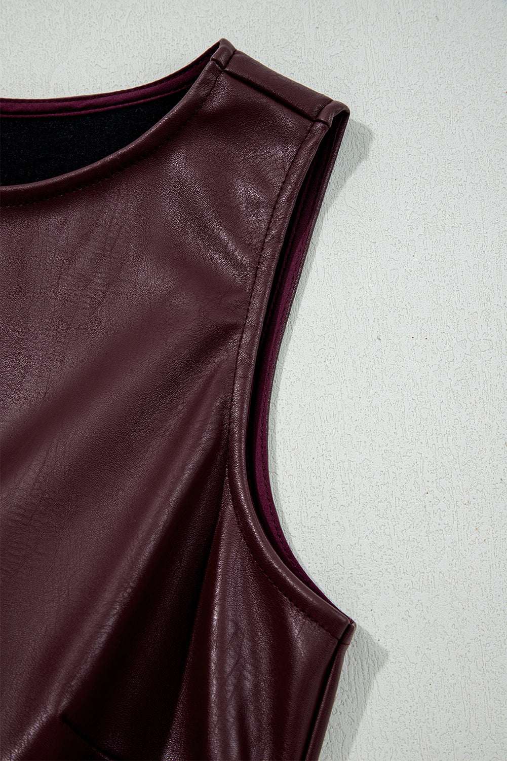 Close-up of armhole and shoulder seam on Brown Faux Leather Sleeveless Mini Dress, emphasizing craftsmanship and texture.