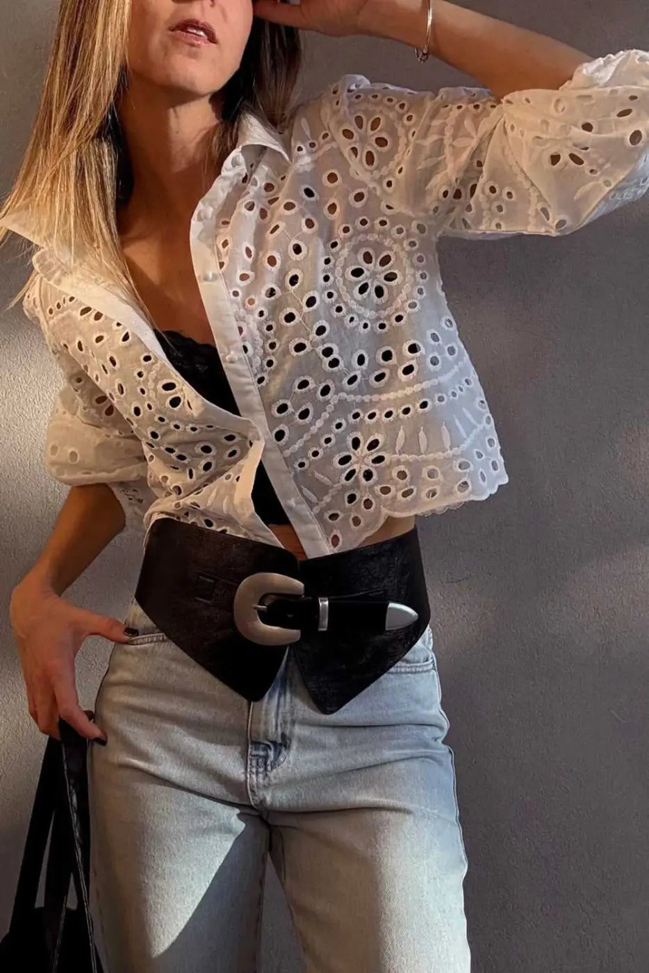 Model wearing White Cutwork Embroidered Crop Top with bold black belt and jeans, perfect for a night out look.