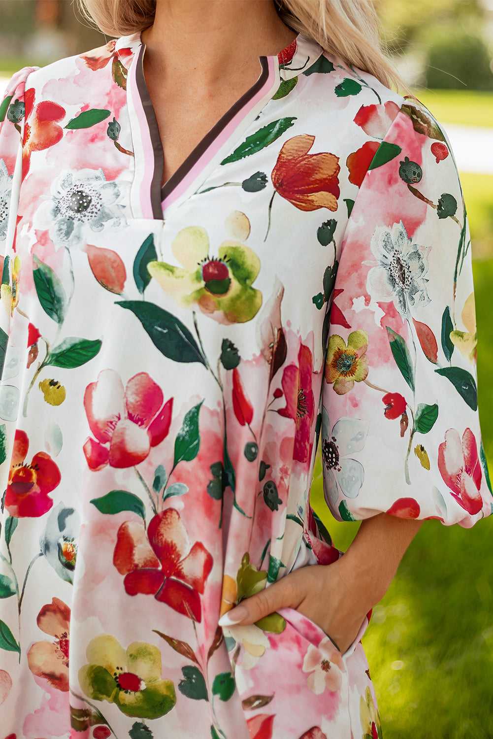 Close-up of Floral Shift Dress - Casual Elegance neckline and pocket, showing contrast trim and vivid floral pattern.
